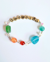 Bracelet with 'SHOWGIRL' beads on a white background