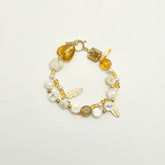 Golden bracelet with “FEARLESS” letter beads and pearl details, top view