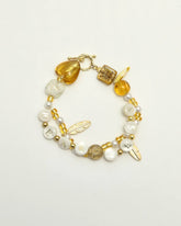 Golden bracelet with “FEARLESS” letter beads and pearl details, top view