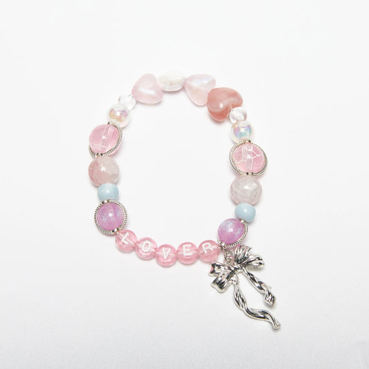 Front view of Lover romantic dreamy bracelet with pink heart-shaped beads and bow charm