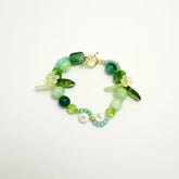 Green bracelet with leaf and flower beads, featuring T and S initials, front view