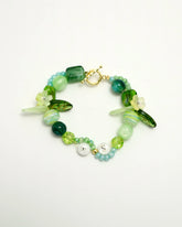 Green bracelet with leaf and flower beads, featuring T and S initials, front view