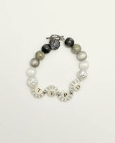 Front view of Tortured Light bracelet featuring TTPD letter beads and silver rose charm