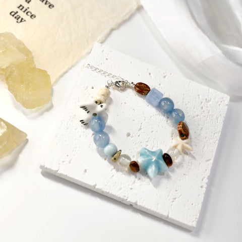 Top view of ocean-themed bracelet styled with yellow crystal and lace