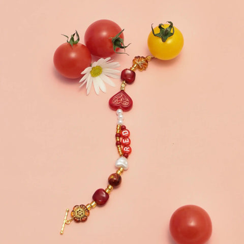 Lifestyle photo of bracelet with floral and tomato props, emotional storytelling