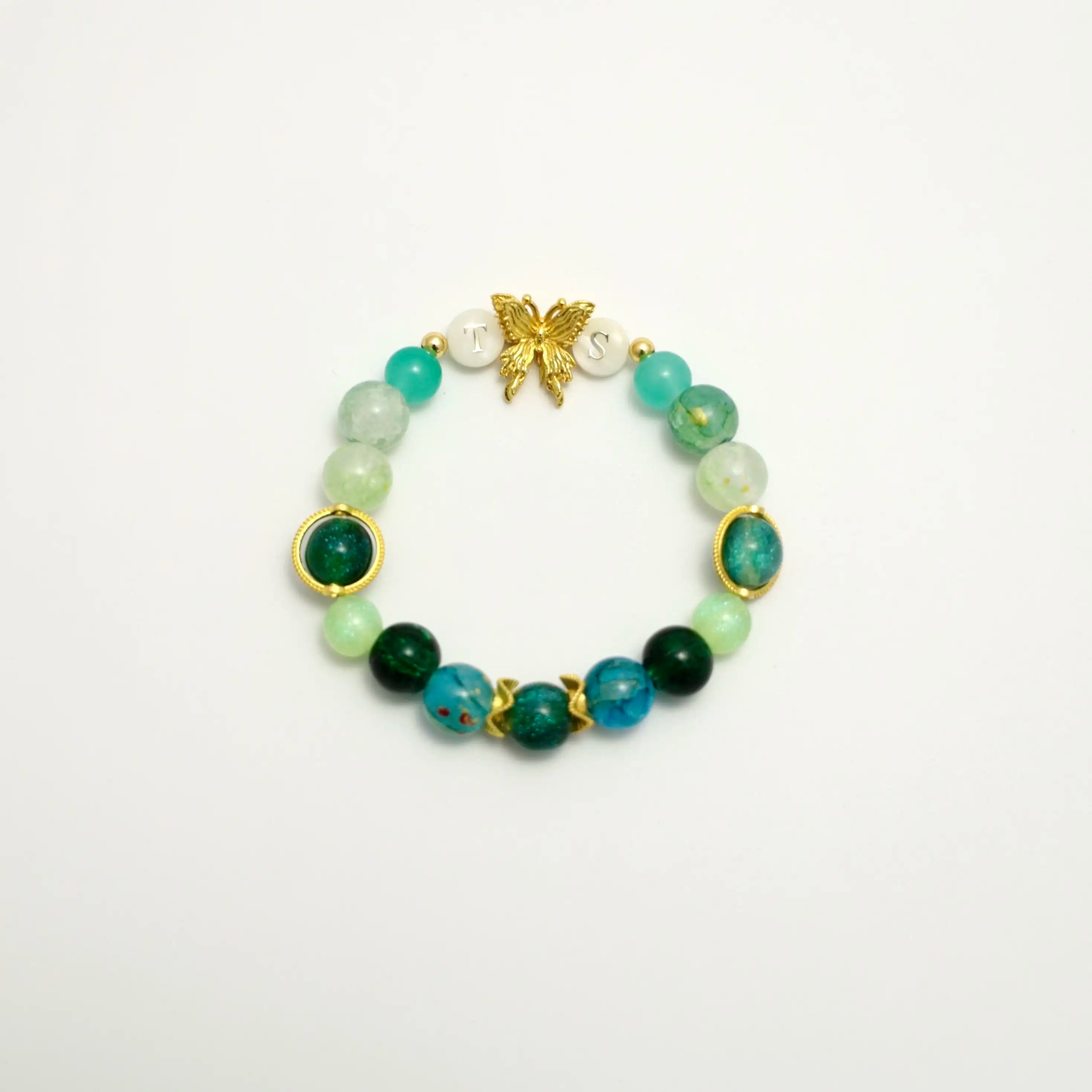 Green beaded bracelet with gold butterfly and TS initials, front view