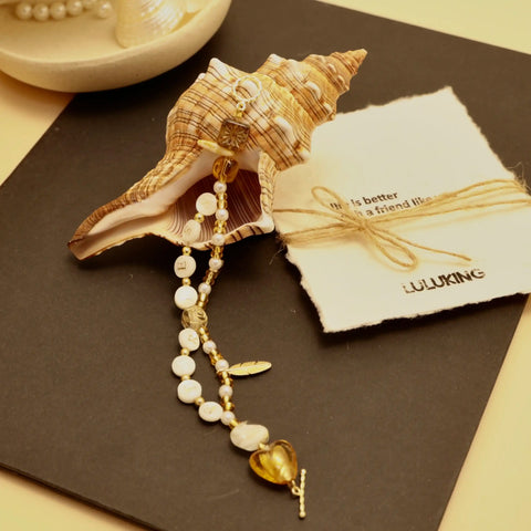 Extended view of gold-tone bracelet with bold FEARLESS letters and metallic accents