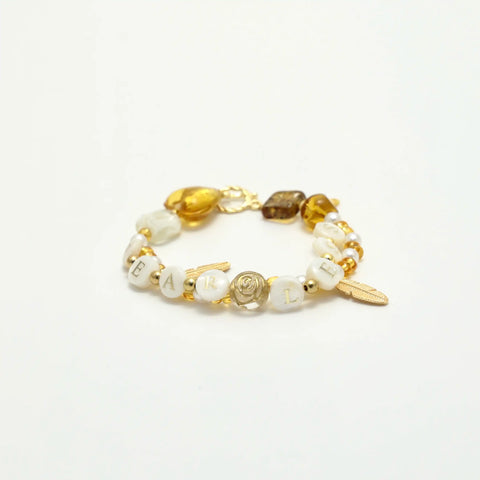 Beaded bracelet with white pearls, gold leaf charms, and FEARLESS text