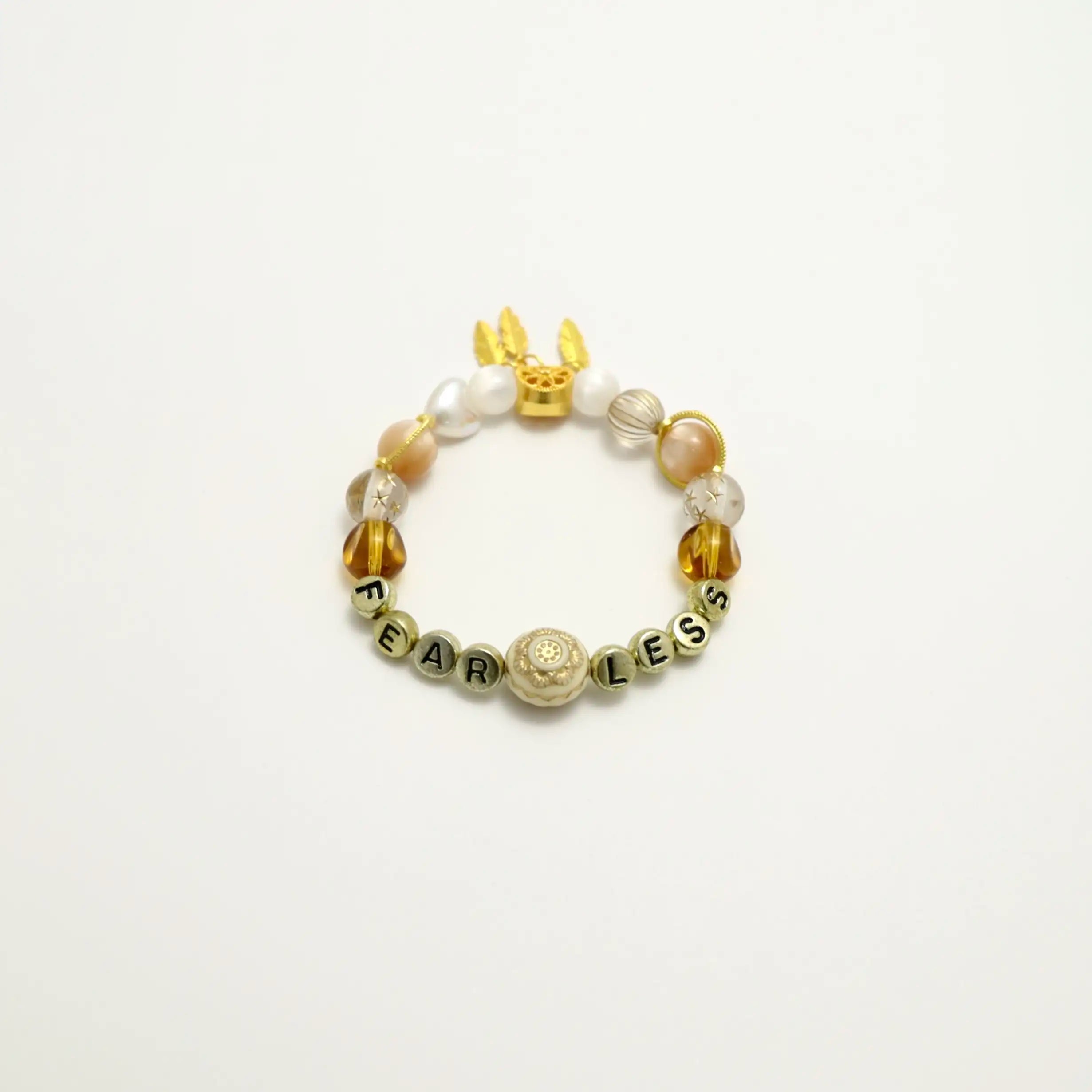 Angled side view of the bracelet featuring caramel and pearl beads with soft glow