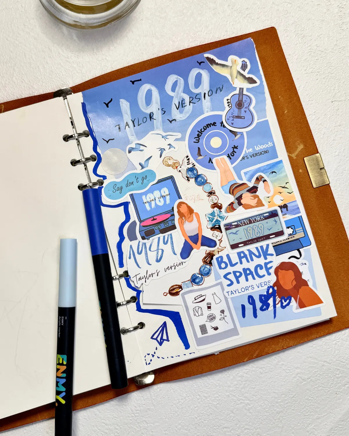 Creative scrapbook page using 1989 era stickers and blue markers, perfect for Swiftie journaling ideas.