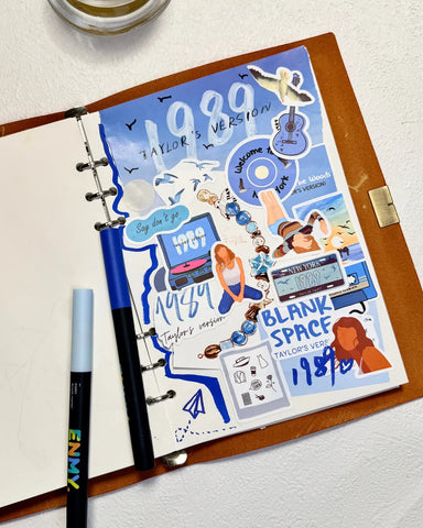 Creative scrapbook page using 1989 era stickers and blue markers, perfect for Swiftie journaling ideas.