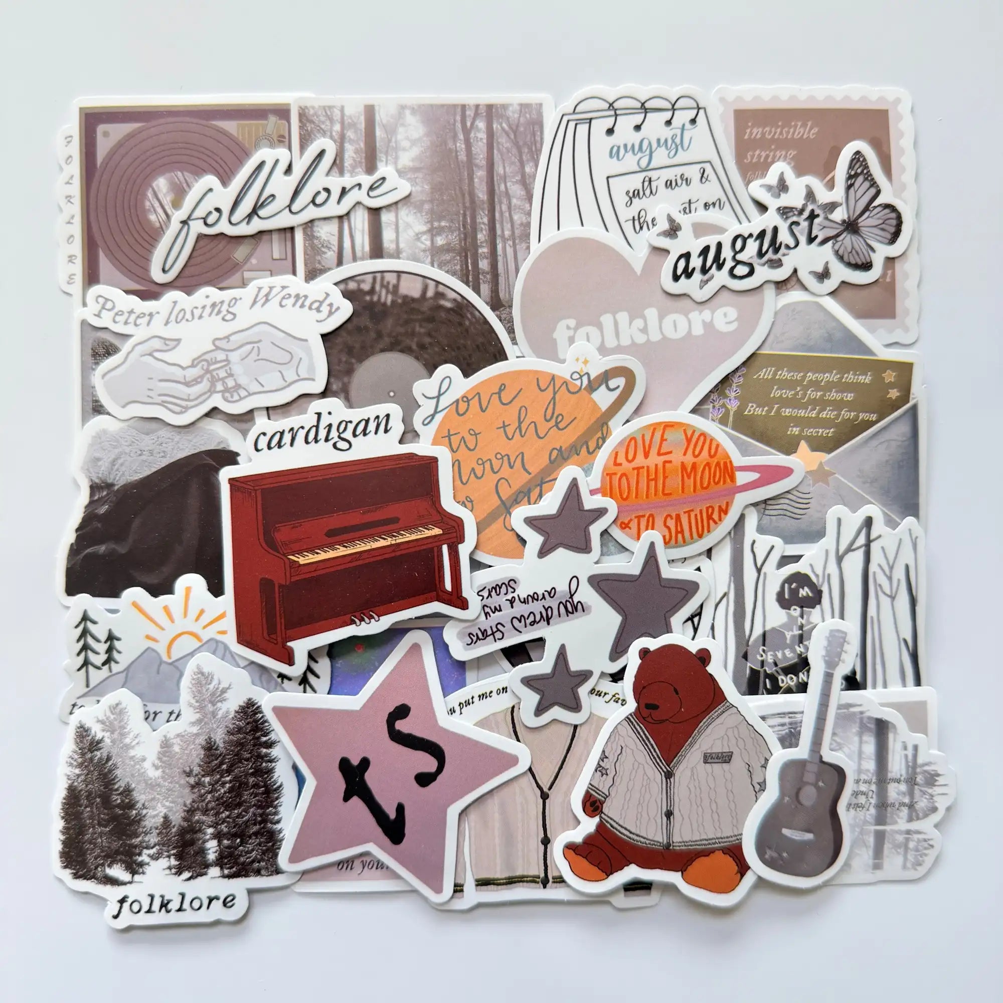 Taylor Swift inspired folklore Swiftie stickers set featuring 50 unique fan-made designs, neutral tones, forest imagery and indie folk album aesthetics