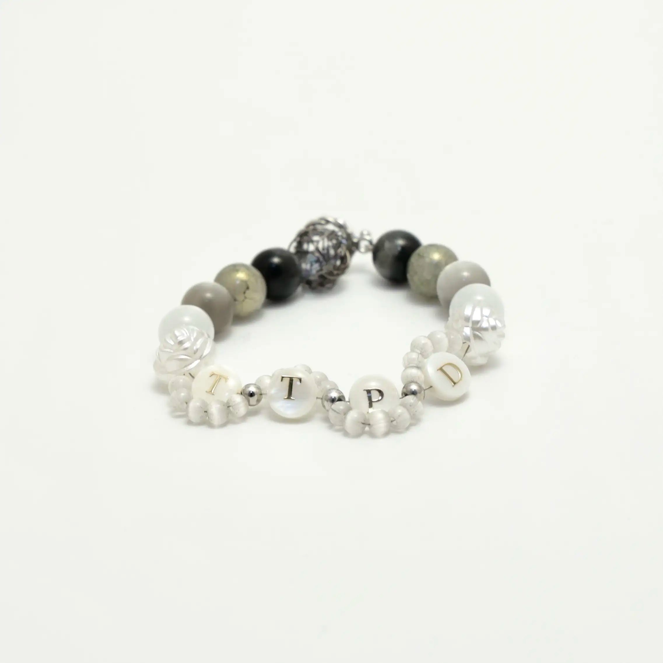 Angled side view showing the mix of matte stones, floral beads, and metallic centerpiece
