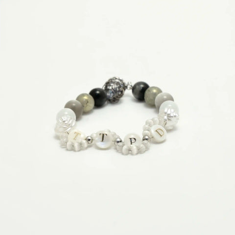 Angled side view showing the mix of matte stones, floral beads, and metallic centerpiece